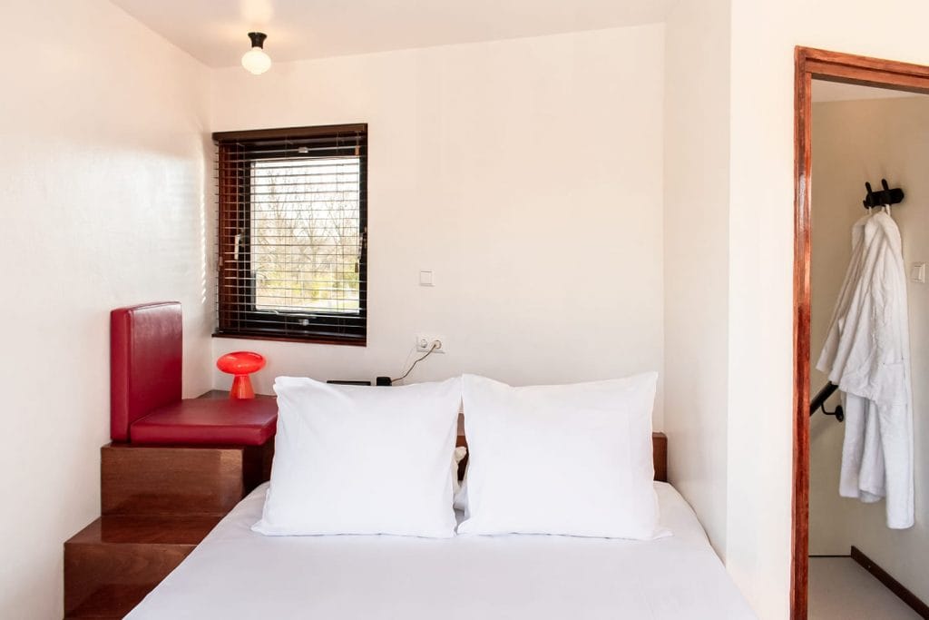 Next to IJdoornlaanbrug's hotel bed is a small seating corner