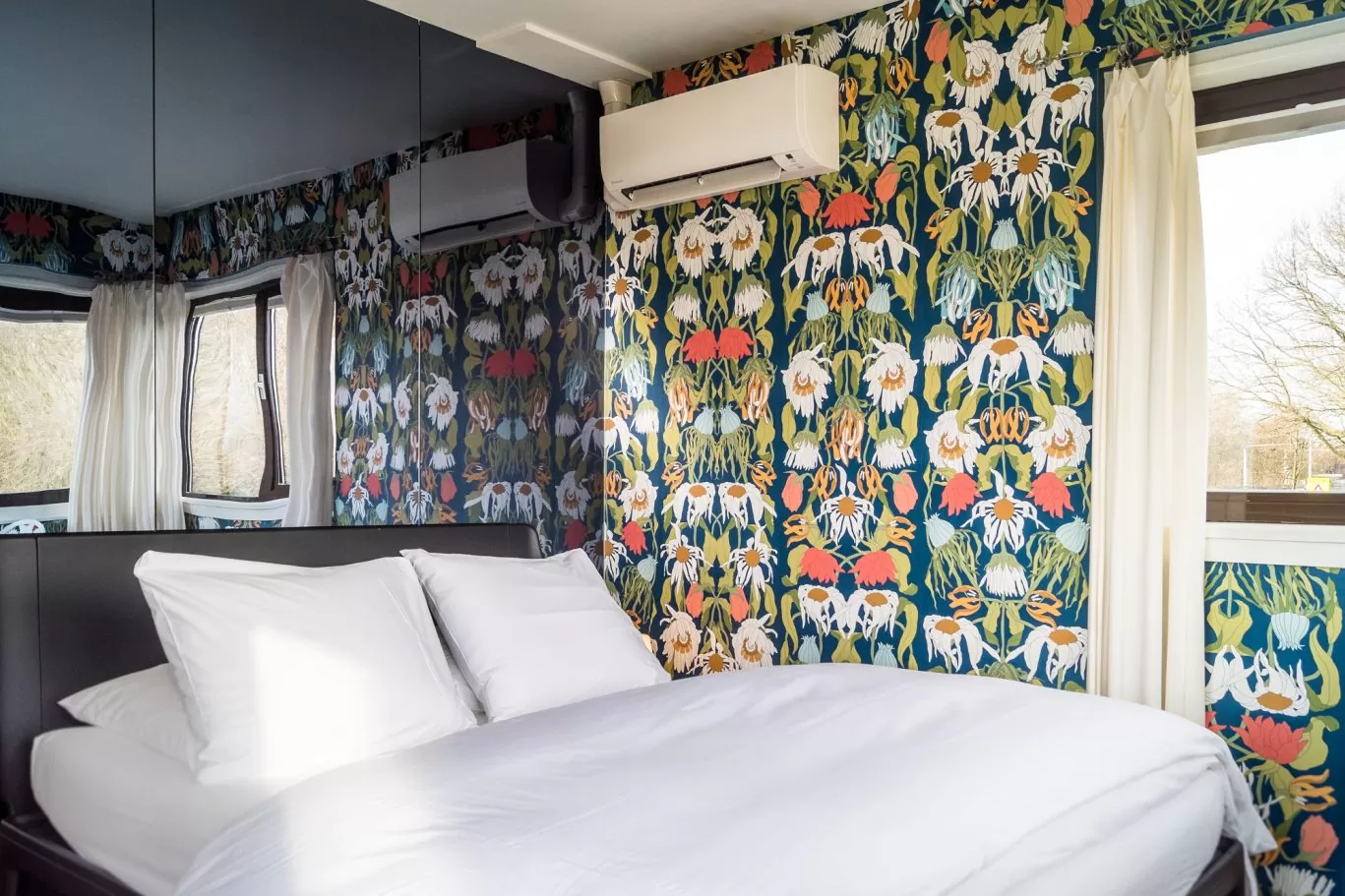 Interior and bed of SWEETS hotel's bridge house 102 Meeuwenpleinbrug with flower wallpaper by Studio Job