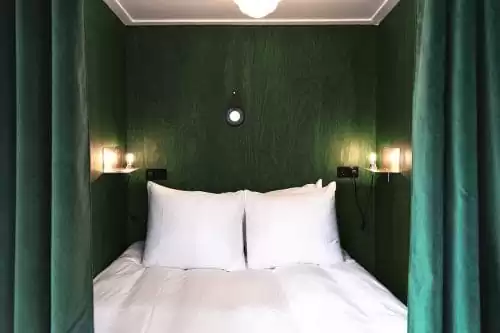Photo of SWEETS hotel Amsterdam West Overtoomsesluis bridge house interior bedroom alcove bed curtains