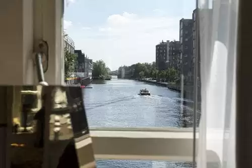 Photo of SWEETS hotel Amsterdam West Van Hallbrug bridge house interior hotel near Amsterdam Center view from bedroom window view boat passing by summer