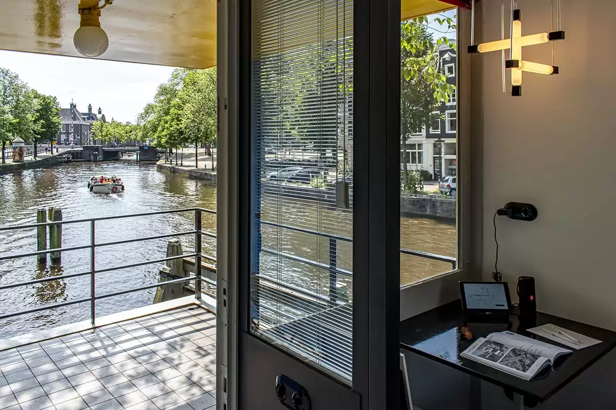 Photo of SWEETS hotel Amsterdam bridge house Hortusbrug hotel near Amsterdam Center nearby Hortus Botanicus entrance living room canal view with boat