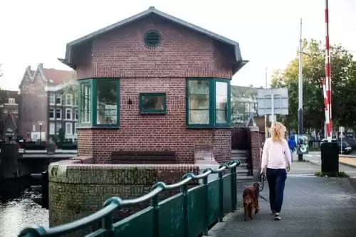 Kattensloot Amsterdam bridge house, woman walking dog, Amsterdam bridge house