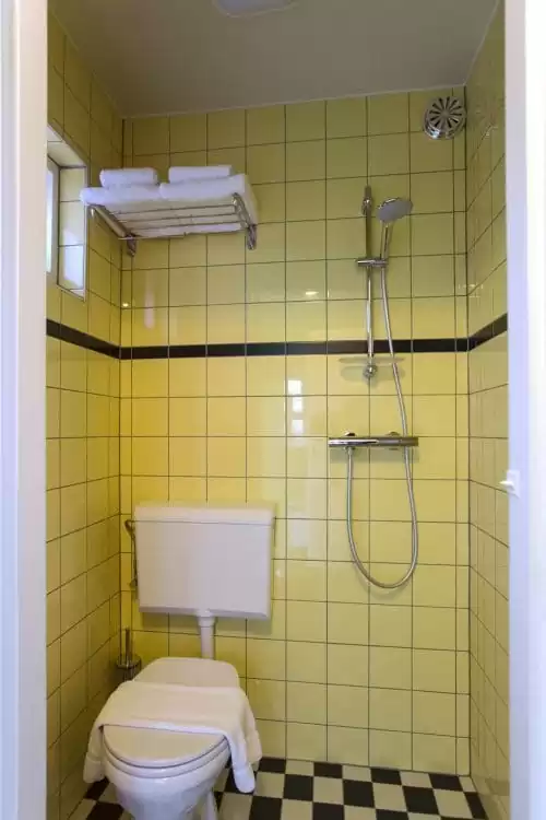 SWEETS hotel Beltbrug bridge house on Amsterdam canals - yellow bathroom with toilet and shower
