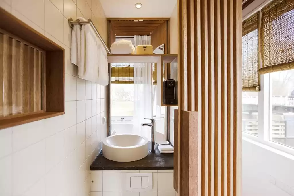Photo of SWEETS hotel Amsterdam Noord North bridge house Buiksloterdraaibrug wooden hotel room interior bathroom sink pantry towels tiny house hotel